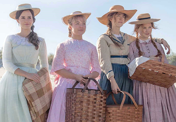 A scene from Little Women - four sisters at the beach wearing hats and carrying a blanket and baskets