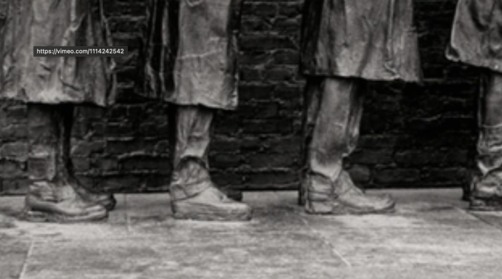 photo of people from the knees down standing in boots and long coat 