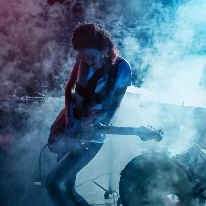 woman playing guitar on stage 