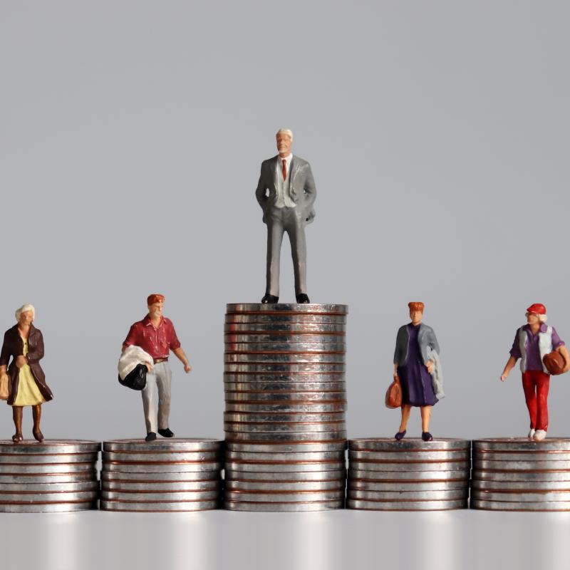 figurines of people standing on stacks of coins