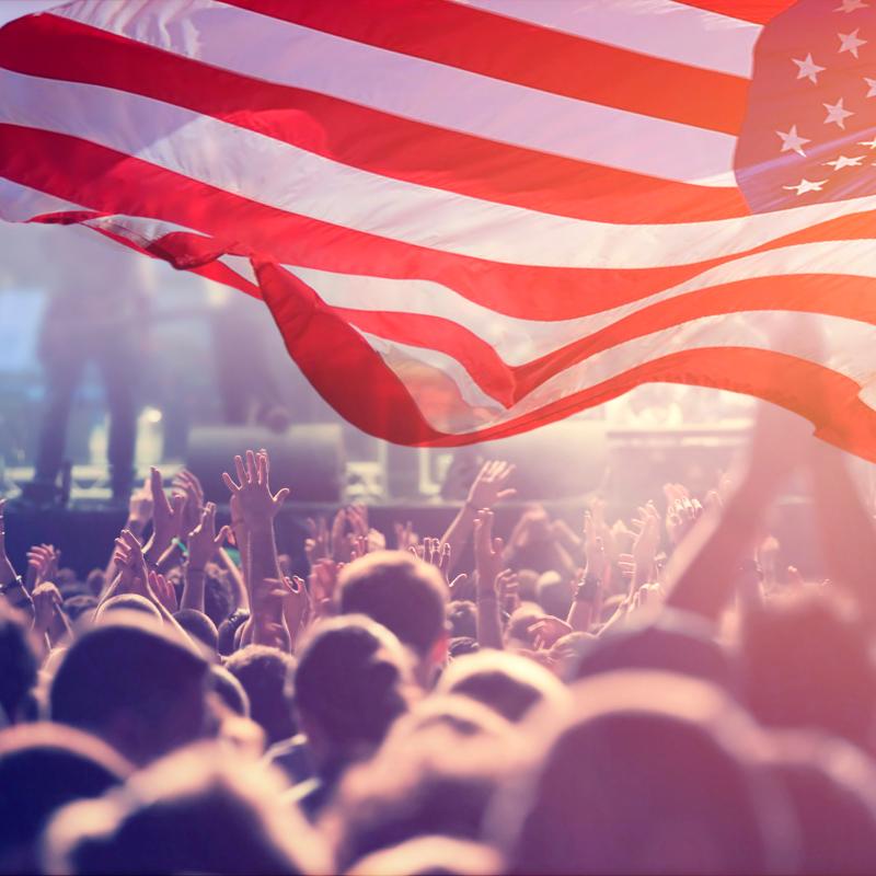 American flag waving over a crowd of people