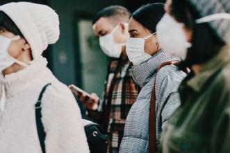 A group of people walking with face masks