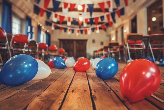 Red, white and blue balloons strewn on the floor and red, white and blue, banners hanging from the ceiling.