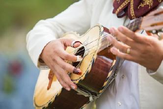 A mariachi musician playing a guitar.