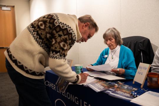 OLLI Ambassador helping member register for classes